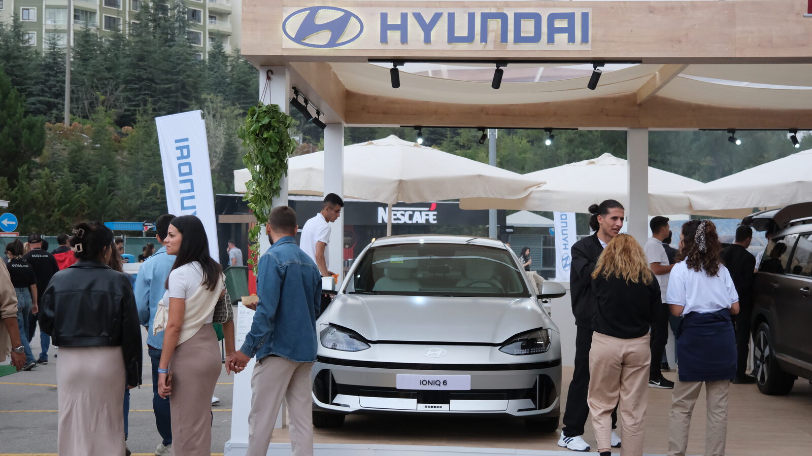 An outdoor stand with a car displayed under a white canopy