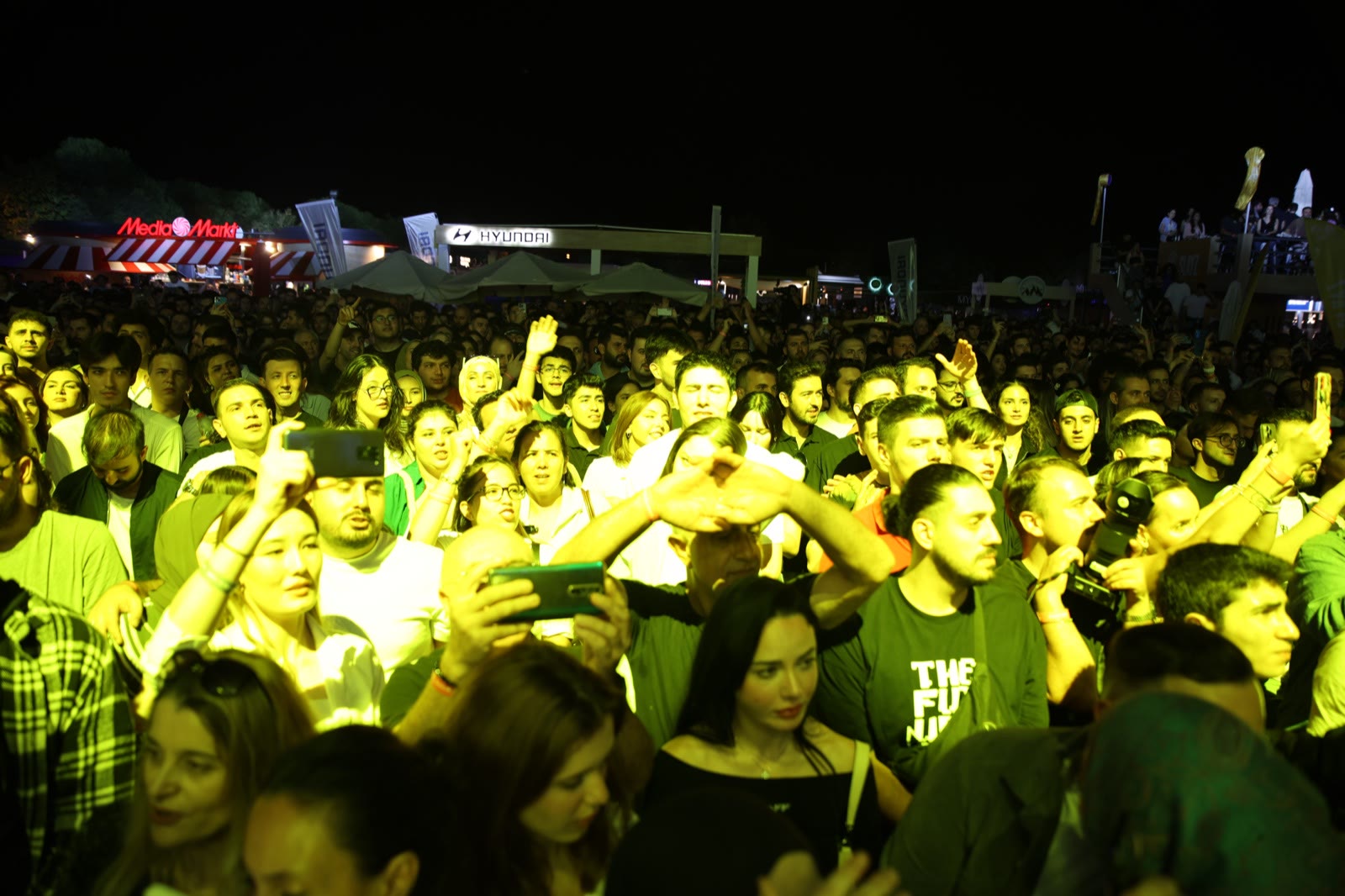 Faces in the crowd at night, phones raised